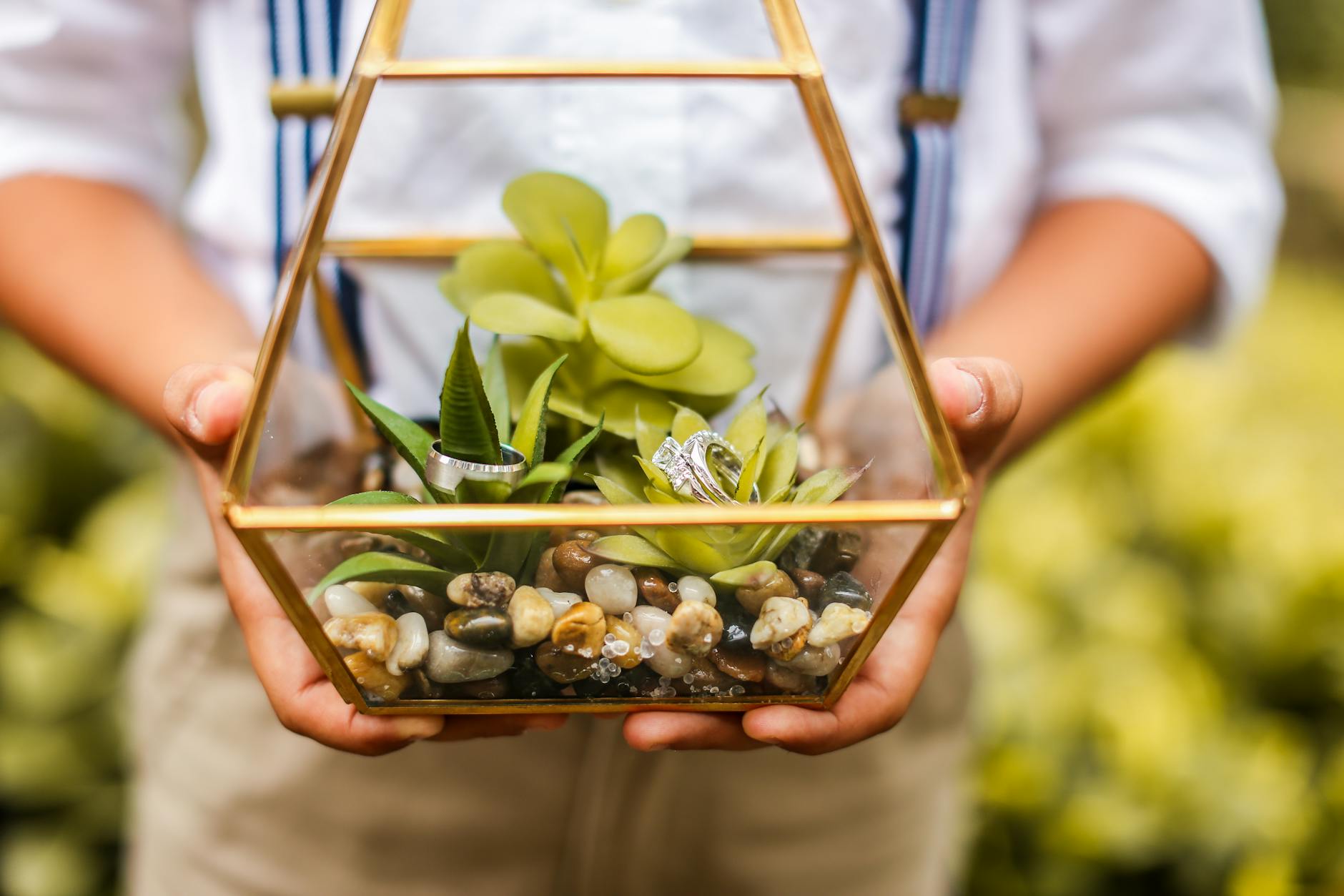 a person carrying glass vase with diamond ring inside